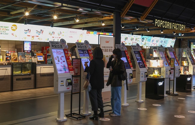 In this file photo taken April 24, 2022, people order snacks at a Seoul theater. (Yonhap)