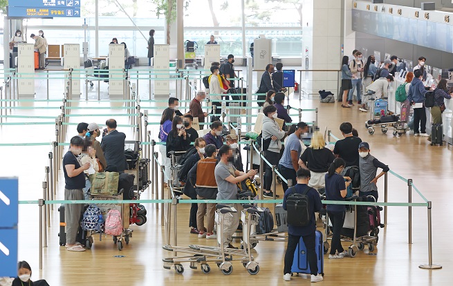 Travelers line up to check in for boarding at Terminal 1 of Incheon International Airport, west of Seoul, on May 13, 2022. (Yonhap)