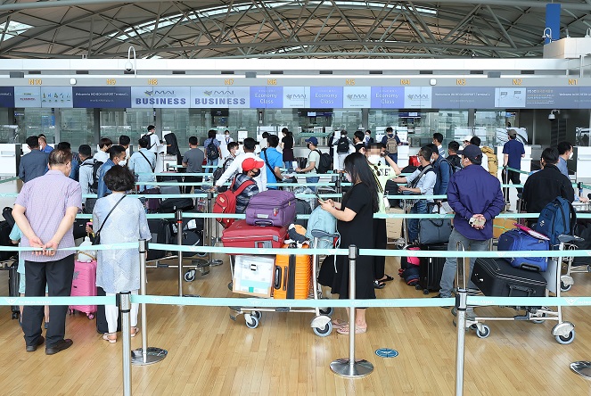 Travelers wait in line at Incheon International Airport in Incheon, west of Seoul, on May 13, 2022. South Korea has decided to ease requirements to enter the country amid a downward trend in COVID-19 cases, a move that could boost convenience for inbound travelers. (Yonhap)