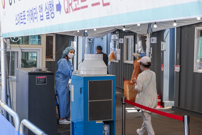 A medical worker guides a visitor at a COVID-19 testing booth near Seoul Station in central Seoul on May 16, 2022. (Yonhap)