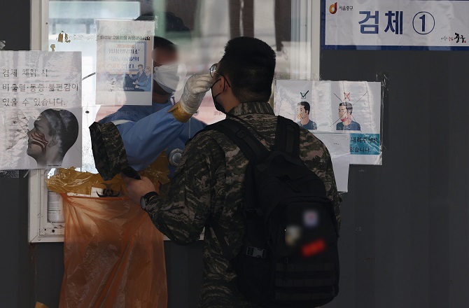 A citizen undergoes a COVID-19 test at a makeshift testing station in Seoul on May 20, 2022. (Yonhap)