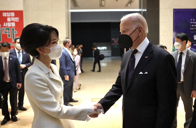 This photo, provided by the presidential office, shows first lady Kim Keon-hee (L) and U.S. President Joe Biden shaking hands ahead of a state dinner at the National Museum of Korea in Seoul on May 21, 2022.