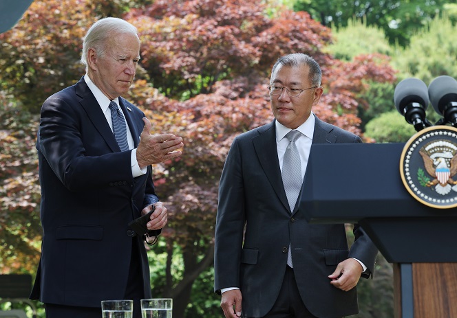 U.S. President Joe Biden guides Hyundai Motor Group Chairman Euisun Chung to the podium for the announcement of an additional investment in the U.S. at the Grand Hyatt Hotel in central Seoul on May 22, 2022. (Yonhap)