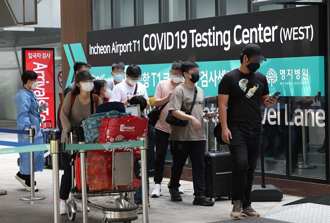 Travelers arriving in South Korea head to a coronavirus testing center at Incheon International Airport, some 40 kilometers west of Seoul, on May 23, 2022. (Yonhap)