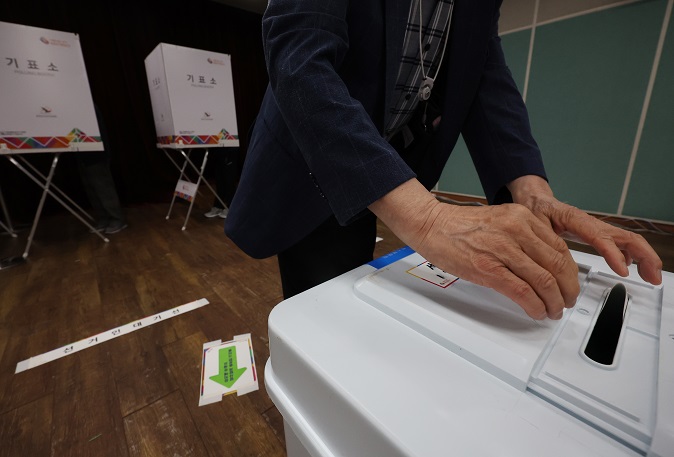 A voter casts his ballot at a polling station in Seoul on May 27, 2022, the first day of two-day early voting for the June 1 local elections and parliamentary by-elections. (Yonhap)