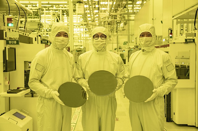 Samsung Electronics executives hold 3-nanometer semiconductor wafers in this photo provided by Samsung Electronics Co. on June 30, 2022. 