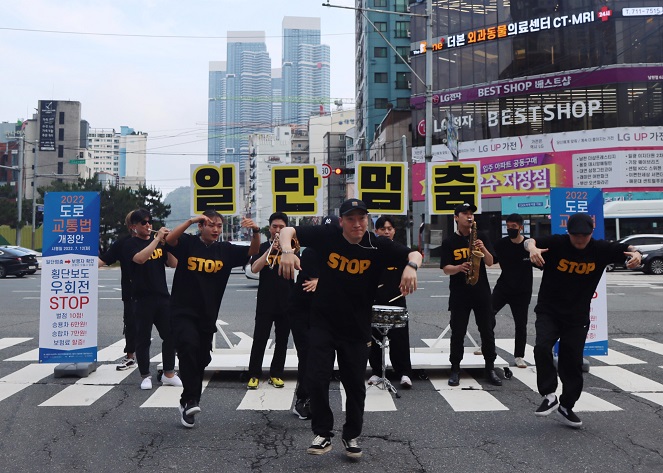 This photo provided by Busan Nambu Police Station shows a youth art group performing at a crosswalk in the southeastern port city of Busan.