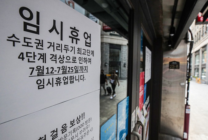 This file photo, taken Aug. 20, 2021, shows a temporary closure sign due to the pandemic that was put up at a restaurant in the shopping district of Myeongdong in central Seoul. (Yonhap)