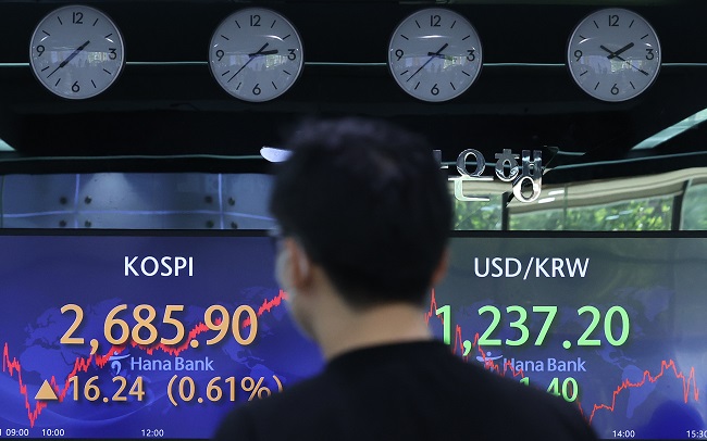A dealer looks at screens displaying the main KOSPI index and won-dollar exchange rate at a Hana Bank branch in central Seoul on May 31, 2022. (Yonhap)