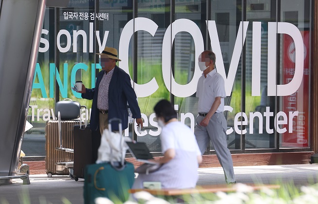 People walk past a coronavirus testing center at Incheon International Airport, west of Seoul, in this file photo taken June 8, 2022. (Yonhap)
