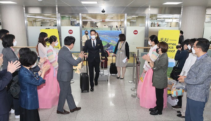 Jeju Island officials welcome international tourists at Jeju International Airport on June 15, 2022. They arrived on the island on Singaporean budget carrier Scoot's aircraft as the company launched a direct flight between Singapore and Jeju. (Yonhap)