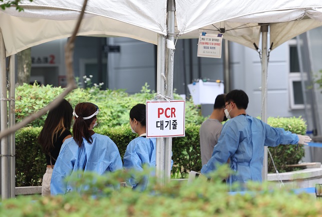 People wait to take COVID-19 tests at a testing center in Seoul on June 17, 2022. (Yonhap)