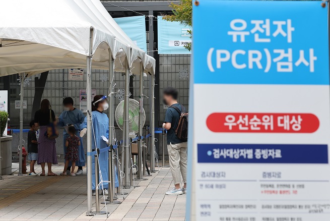 A health worker guides a visitor at a COVID-19 testing station in Seoul's southern district of Seocho on June 17, 2022. (Yonhap)