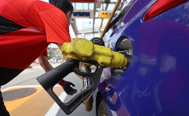 An employee pumps gas into a car at a filling station in Seoul on June 22, 2022. (Yonhap)