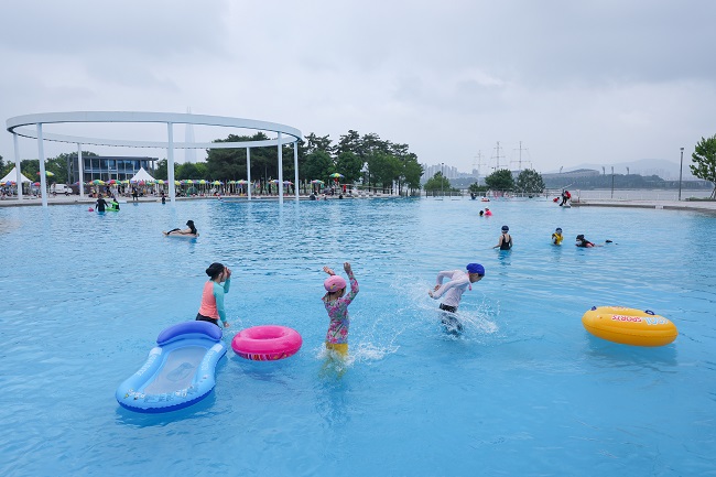 People play in a riverside swimming pool in Seoul on June 24, 2022, as four outdoor swimming pools and two wading pools on the banks of the Han River opened the same day following a two-year hiatus due to the COVID-19 pandemic. (Yonhap)