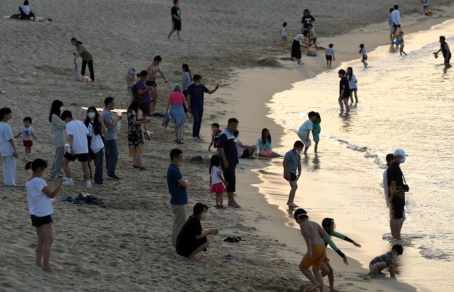 People are out late at the beach in Gangneung Province on June, 26, 2022, to seek refuge from the hot weather that did not cool down even after sunset. (Yonhap)