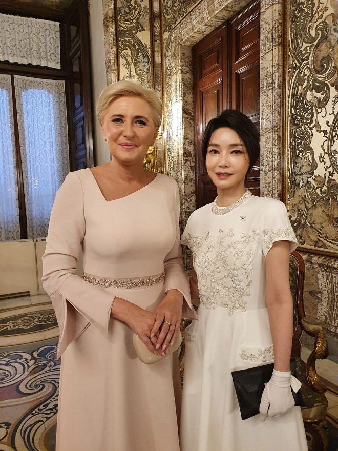 This photo, provided by the presidential office, shows first lady Kim Keon-hee (R) and Polish first lady Agata Kornhauser-Duda posing for a photo at a gala dinner held at the Royal Palace of Madrid on June 28, 2022.