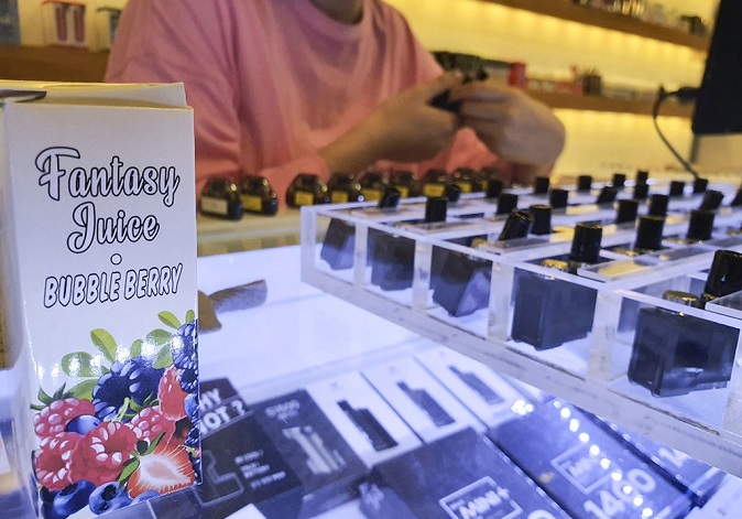 A clerk at an e-cigarette store in Seoul introduces products on Oct. 23, 2019. (Yonhap)