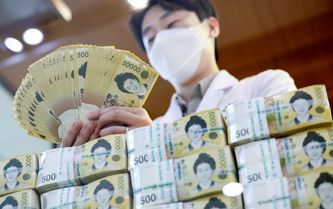 An official checks banknotes at the headquarters of KEB Hana Bank in Seoul on Jan. 7, 2022. (Yonhap)