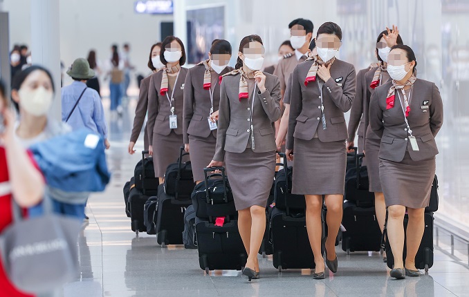 This undated photo shows flight attendants and passengers at a South Korean airport. (Yonhap)