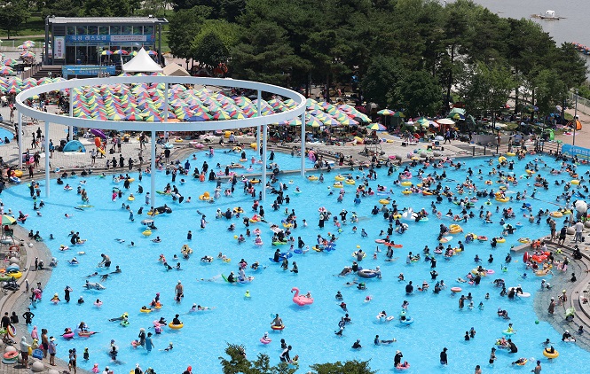 Giant swimming facilities at a public park in Ddukseom, eastern Seoul, bustle with visitors, in this July 3, 2022, file photo. (Yonhap)