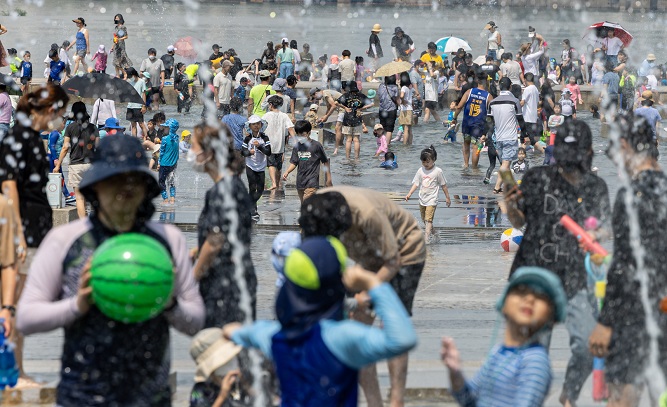 A riverside park in Yeouido, Seoul, bustles with vacationers amid a scorching heat wave on July 3, 2022. (Yonhap)