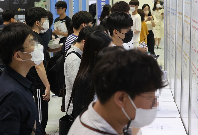 In this file photo, job seekers look at employment information at a job fair held at the Convention and Exhibition Center in southern Seoul on July 5, 2022. (Yonhap)