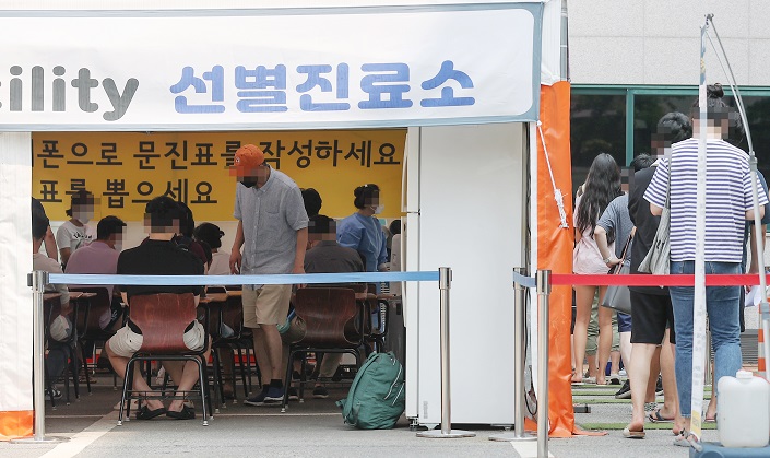 A COVID-19 testing station in Seoul is crowded with people on July 10, 2022. (Yonhap)