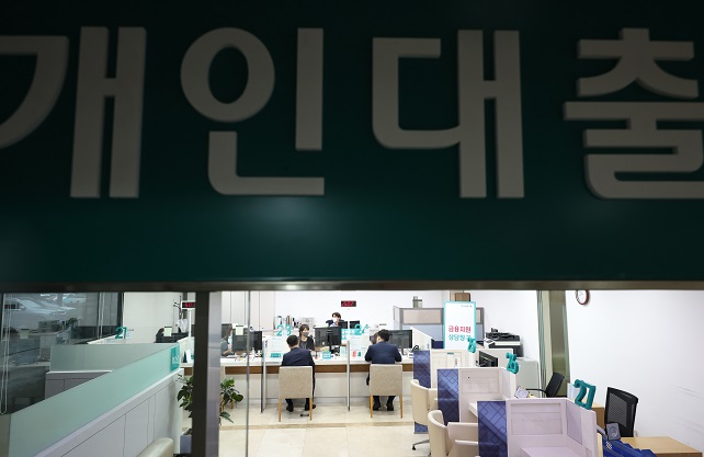This file photo taken July 13, 2022, shows bank officials providing consultations on loan programs with customers at a lender in Seoul. (Yonhap)