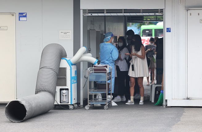 People wait in line to take COVID-19 diagnostic tests at a temporary testing station at a bus terminal in southern Seoul on July 27, 2022. (Yonhap)