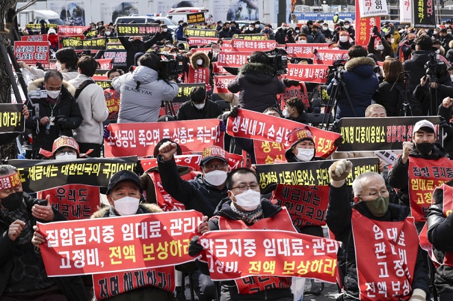 Protestors chant slogans in Seoul on Feb. 15, 2022, as representatives from a national coalition of self-employed workers stage a rally to call for the lifting of the government's restrictions on their business hours and compensation for losses faced by the industry due to the coronavirus pandemic. (Yonhap)