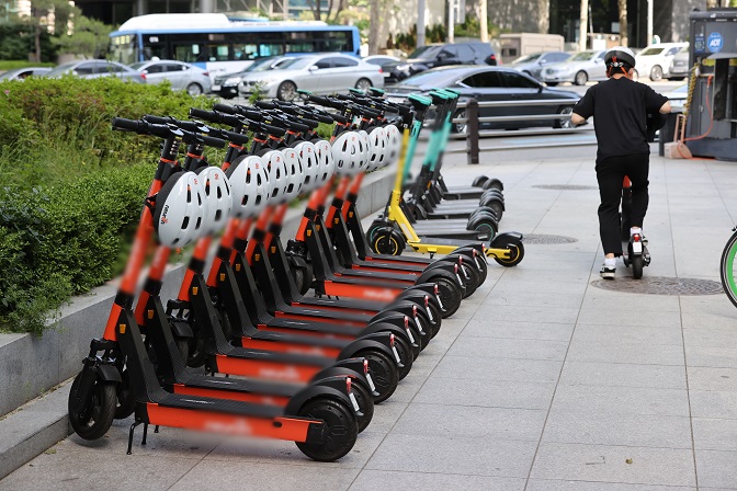 In this file photo from Oct. 29, 2021, electric scooters are parked by a road in Seoul. (Yonhap)
