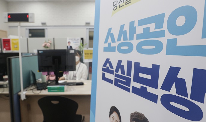 This file photo, taken June 30, 2022, shows a banner set up at an agency designed to support small merchants in Seoul that says pandemic-hit merchants can apply for state compensation for their losses caused by the government's virus restrictions. (Yonhap)
