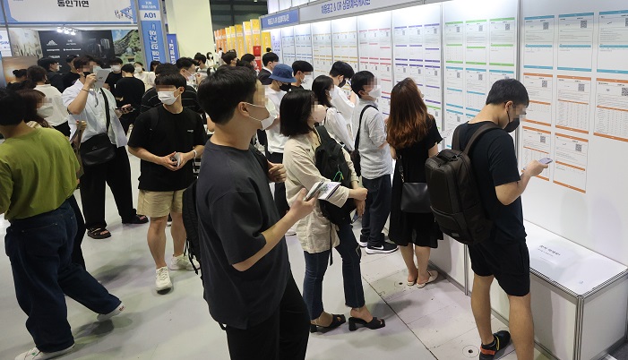 In this file photo, jobseekers look at employment information at a job fair held at the Convention and Exhibition Center in southern Seoul on July 5, 2022. (Yonhap)