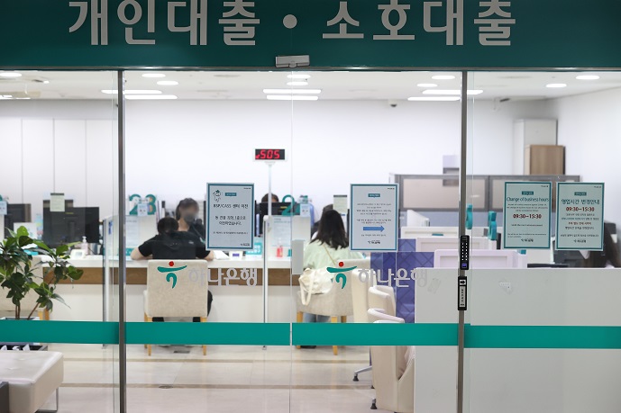 This photo, taken Aug. 1, 2022, shows bank officials providing consultations on loan programs to customers at a Hana Bank branch in Seoul. (Yonhap)