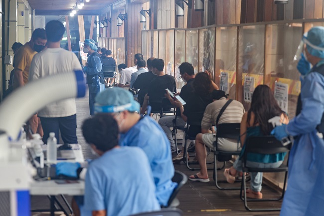 People sit in line to receive tests at a COVID-19 testing center in Seoul on Aug. 2, 2022. (Yonhap)
