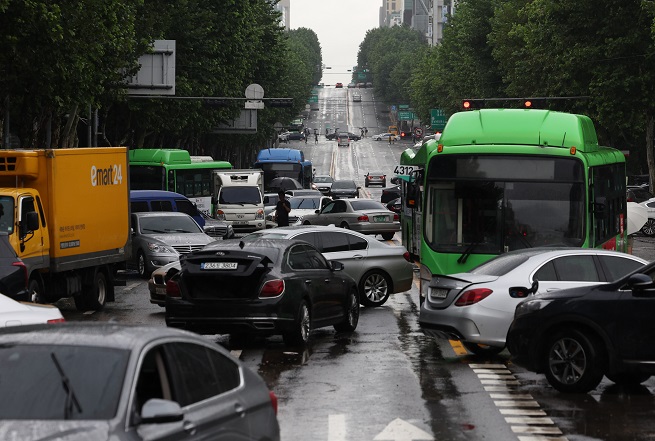 Cars abandoned by motorists amid heavy downpours and ensuing flash floods sit unattended on a road near Daechi Station in southern Seoul on Aug. 9, 2022. (Yonhap)