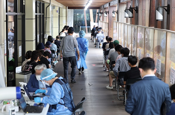 People wait to undergo a COVID-19 virus test at a makeshift testing station in Seoul on Aug. 17, 2022. (Yonhap)