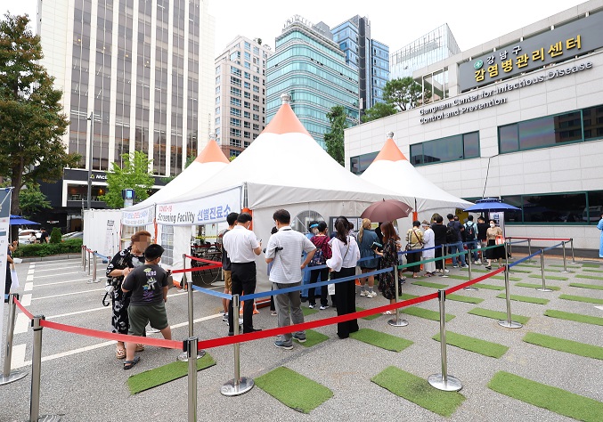 People wait to take a COVID-19 test at a clinic in Gangnam, southern Seoul, on Aug, 25, 2022. (Yonhap)