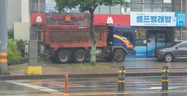 Dump Trucks Protect Glass Storefronts from Typhoon