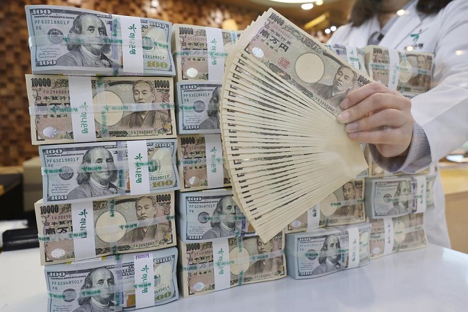 A clerk scrutinizes 10,000 yen Japanese banknotes at the headquarters of Hana Bank in Seoul on April 20, 2022, to see whether there are any counterfeit bills. (Yonhap)