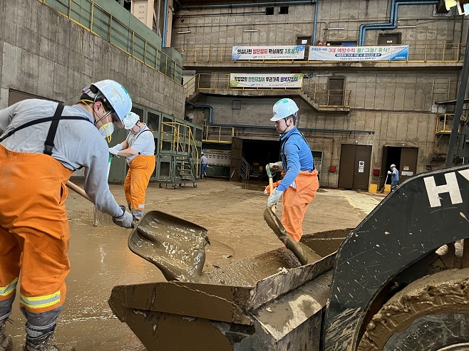 Workers remove mud at POSCO in the southeastern city of Pohang on Sept. 7, 2022, in this photo provided by the steelmaker. Many parts of the steel mill, except for a furnace, were flooded by 110 millimeters of torrential rains per hour caused by the super strong Typhoon Hinnamnor that pounded the region the previous day, crippling its operation. The reopening of the plant is expected to require five days.