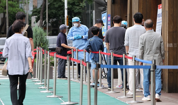 This photo taken Sept. 13, 2022, shows people waiting to take a COVID-19 test at a clinic in Songpa, eastern Seoul. (Yonhap)