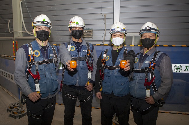 This photo provided by LG Uplus Corp. shows engineers from Hyundai Elevator Co. equipped with smart devices.