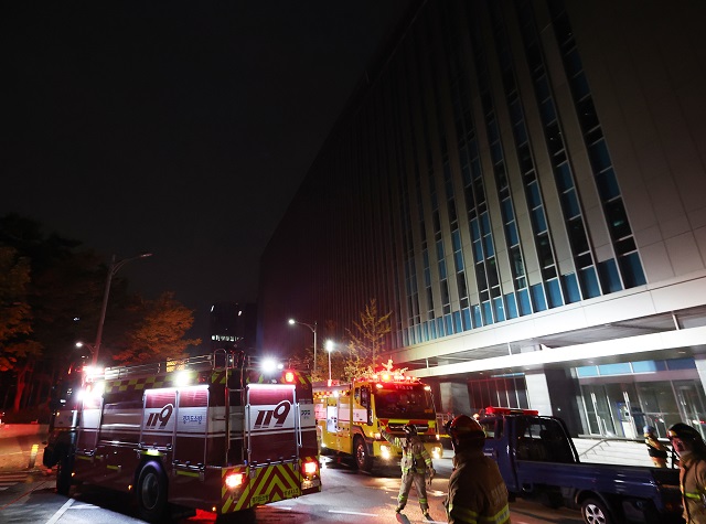 Firefighters work in front of a building of SK C&C in Pangyo, just south of Seoul, on Oct. 15, 2022, after a fire broke out there. (Yonhap)