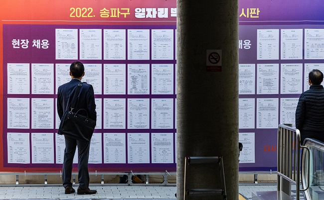 Job seekers read a notice board at a job fair in Seoul on Oct. 19, 2022. (Yonhap)