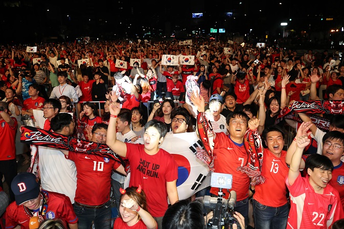 Sports fans cheer for the national team on a street in South Korea during the 2018 World Cup in Russia. (Yonhap)