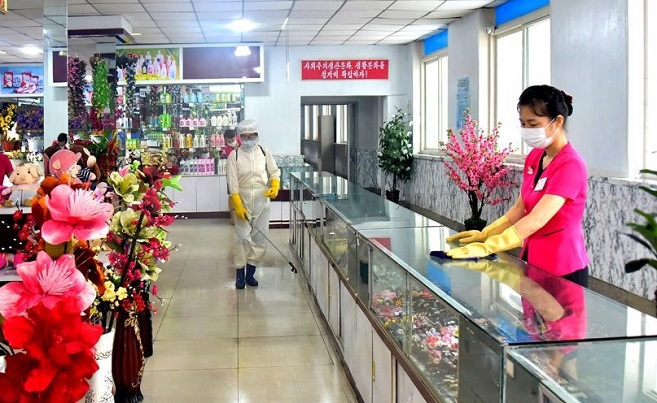 In this file photo released by North Korea's official Korean Central News Agency on Aug. 8, 2022, store workers disinfect a shop in Pyongyang as the North steps up efforts to prevent the spread of COVID-19. (Yonhap)