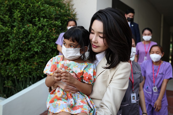 First lady Kim Keon-hee holds a child while visiting Hebron Medical Center in Phnom Penh on Nov. 11, 2022, in this photo provided by the presidential office. 