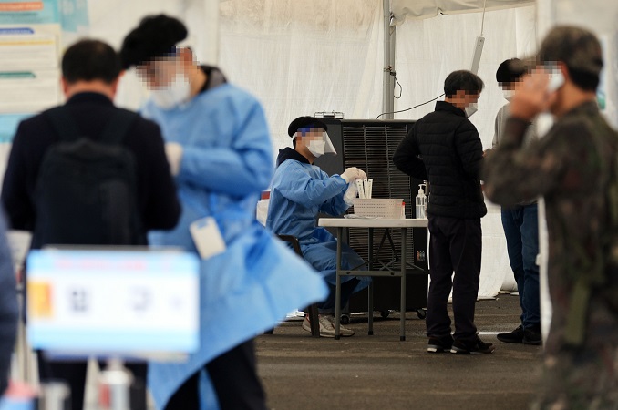 People undergo COVID-19 tests at a makeshift testing station in Seoul on Nov. 13, 2022. (Yonhap)